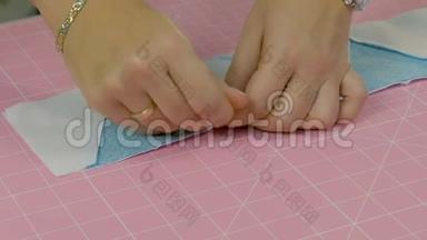 女裁缝用别针把布连接起来。 在缝纫机上做工件。